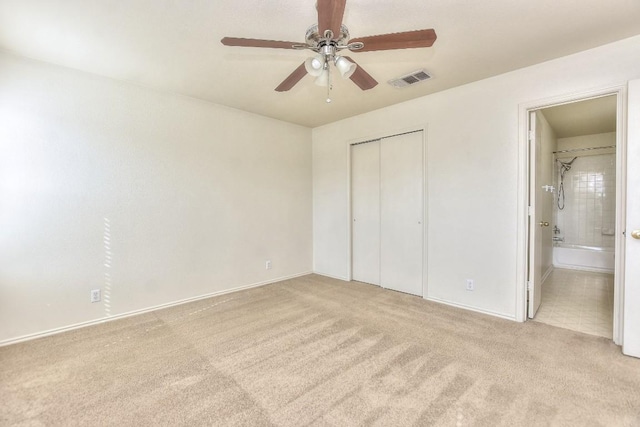 unfurnished bedroom featuring visible vents, ceiling fan, ensuite bathroom, carpet flooring, and a closet