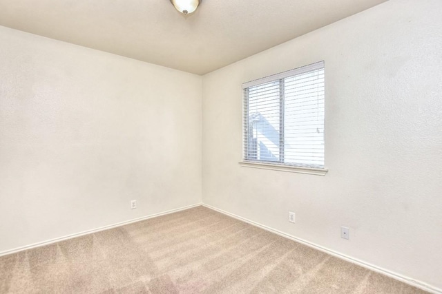 carpeted empty room with baseboards