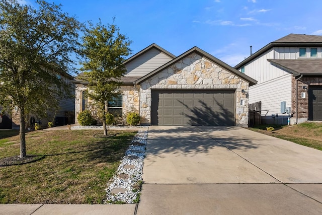 view of front facade with a garage, driveway, stone siding, and a front yard