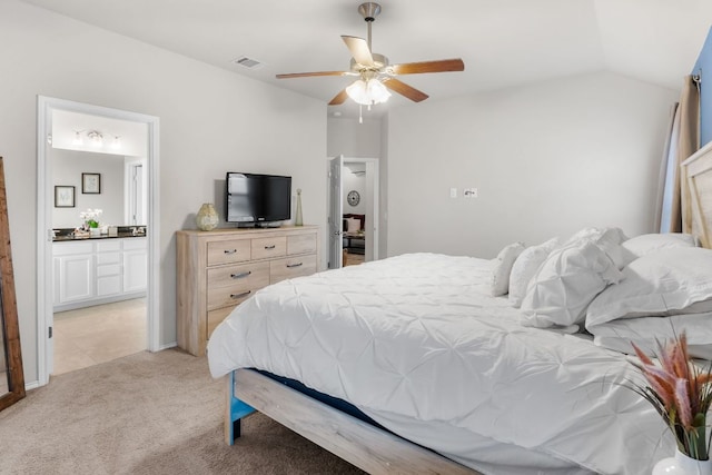 bedroom with ensuite bathroom, light carpet, a ceiling fan, visible vents, and vaulted ceiling