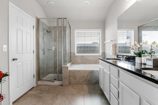 bathroom featuring a garden tub, a sink, vaulted ceiling, a shower stall, and double vanity