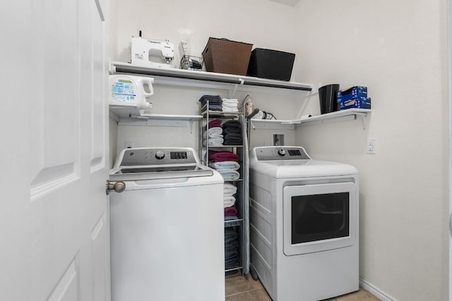 clothes washing area with washing machine and dryer, laundry area, and tile patterned floors