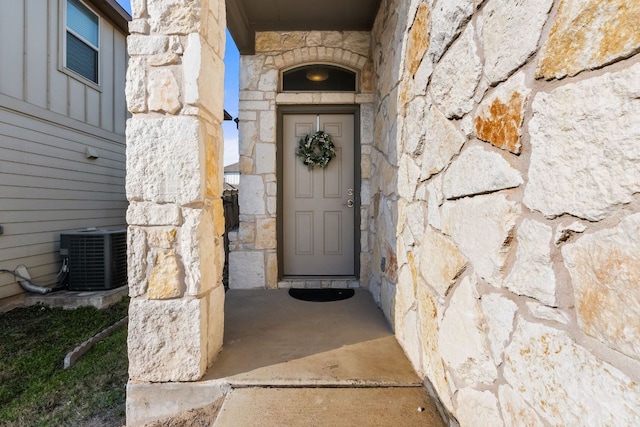 entrance to property with stone siding and central AC unit