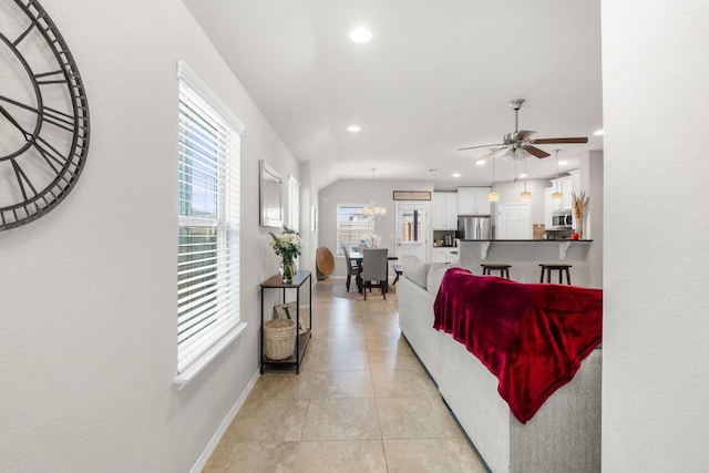 living room with recessed lighting, ceiling fan with notable chandelier, baseboards, and light tile patterned flooring