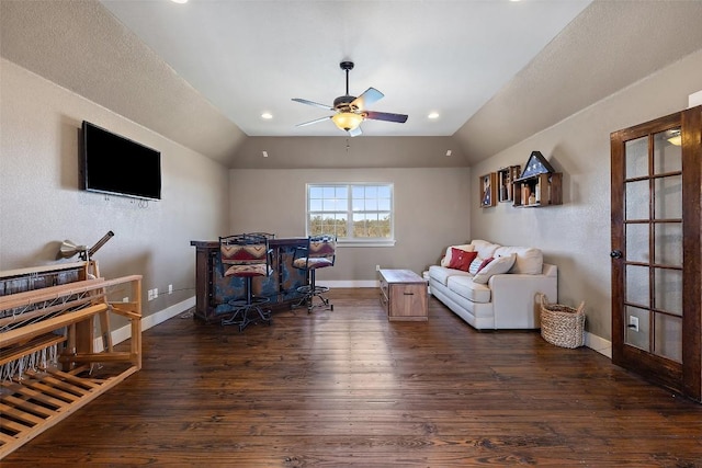 living area with baseboards, dark wood-style flooring, vaulted ceiling, and a ceiling fan