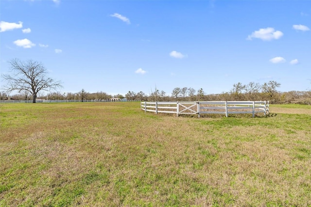 view of yard with fence and a rural view