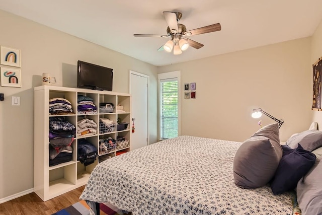 bedroom featuring ceiling fan, baseboards, and wood finished floors