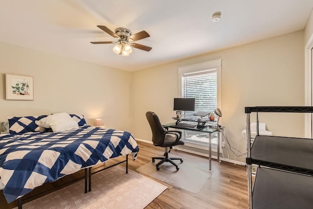 bedroom featuring a ceiling fan, baseboards, and wood finished floors