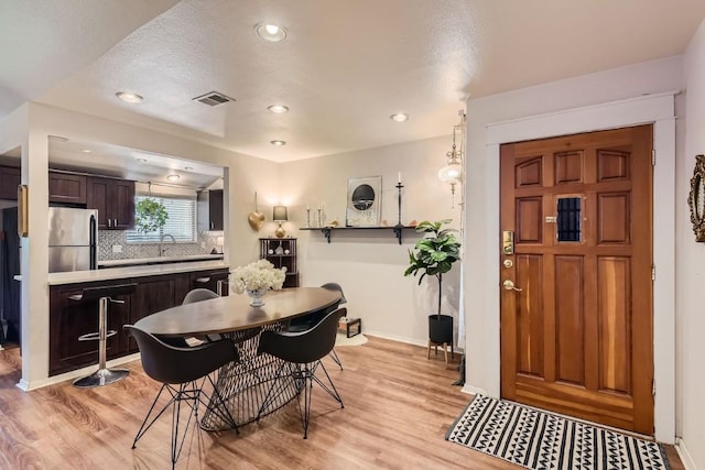 dining area with recessed lighting, visible vents, light wood-style flooring, and baseboards