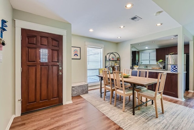 dining room featuring light wood-type flooring, baseboards, visible vents, and recessed lighting