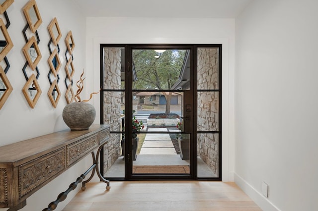 foyer featuring baseboards and wood finished floors