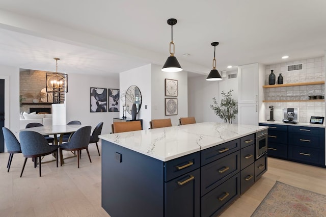 kitchen with light wood-style floors, tasteful backsplash, visible vents, and open shelves