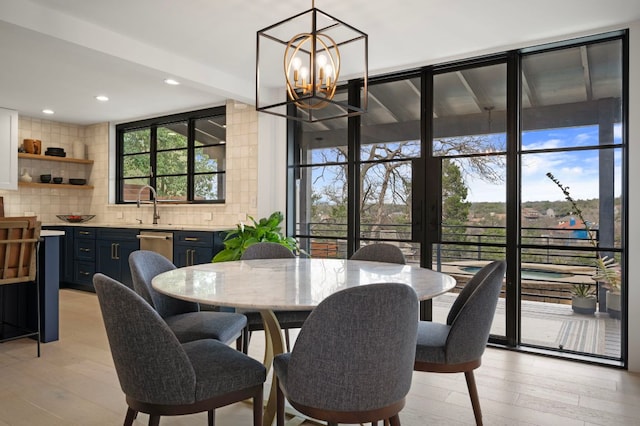 dining area featuring a wealth of natural light, light wood-style flooring, recessed lighting, and an inviting chandelier