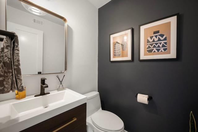 bathroom featuring visible vents, vanity, and toilet