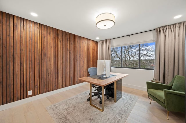 office space featuring light wood-style floors, recessed lighting, wooden walls, and baseboards