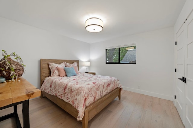 bedroom featuring light wood-style flooring and baseboards