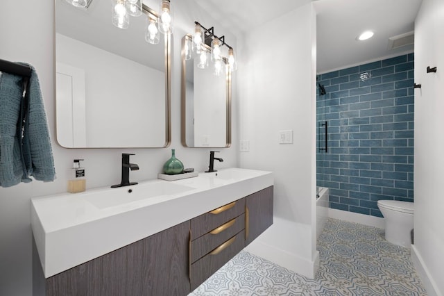 bathroom with toilet, tile patterned flooring, double vanity, and a sink