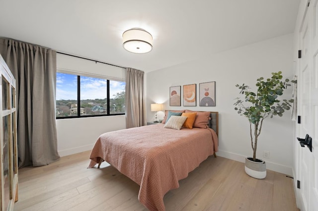 bedroom featuring light wood-style floors and baseboards