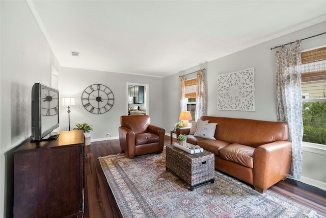 living room with baseboards, plenty of natural light, visible vents, and wood finished floors