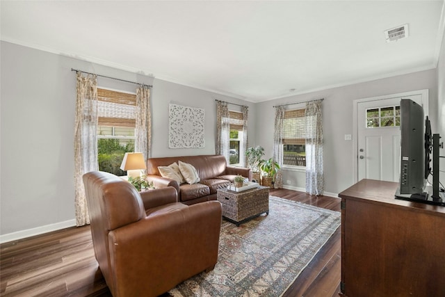 living area with dark wood-style floors, baseboards, visible vents, and crown molding