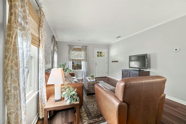 living area featuring ornamental molding, visible vents, baseboards, and wood finished floors