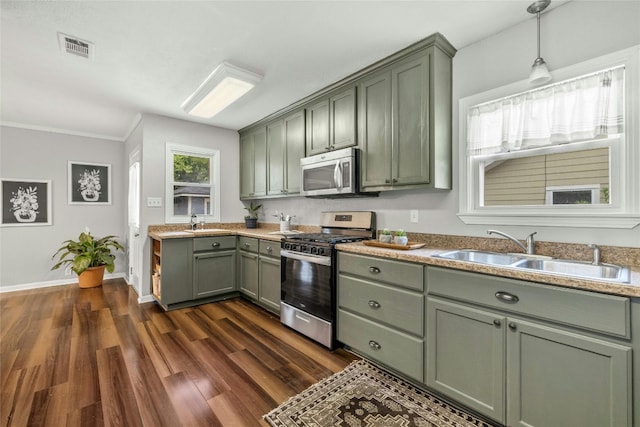 kitchen with visible vents, dark wood finished floors, appliances with stainless steel finishes, a sink, and green cabinetry