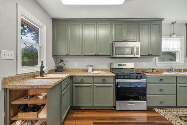 kitchen with appliances with stainless steel finishes, dark wood-style floors, green cabinets, and open shelves