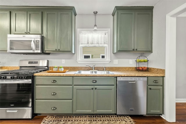 kitchen featuring appliances with stainless steel finishes, green cabinets, and a sink