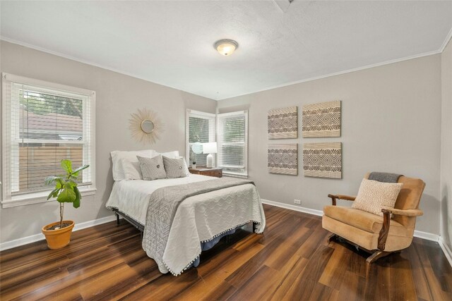 bedroom with ornamental molding, dark wood finished floors, and baseboards