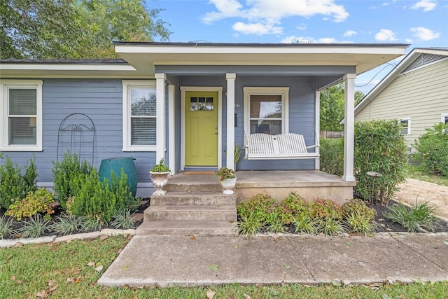 view of exterior entry with a porch