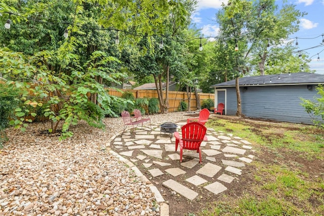 view of yard with a patio area, fence, and a fire pit