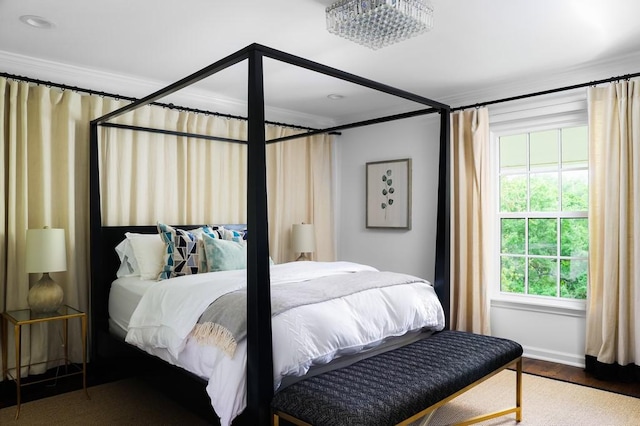 bedroom with wood finished floors and crown molding