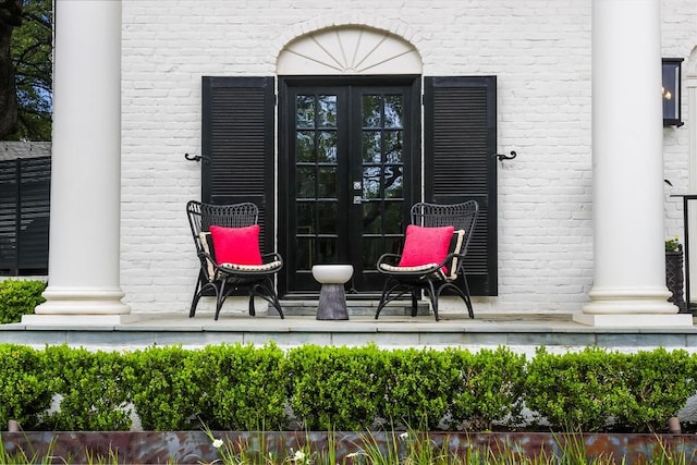 entrance to property featuring french doors and brick siding