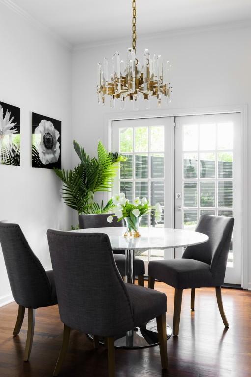 dining room featuring a healthy amount of sunlight, wood finished floors, and crown molding