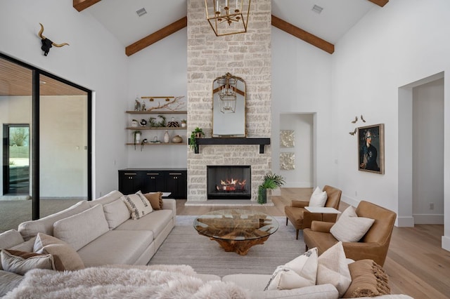 living room featuring a fireplace, visible vents, wood finished floors, beamed ceiling, and baseboards