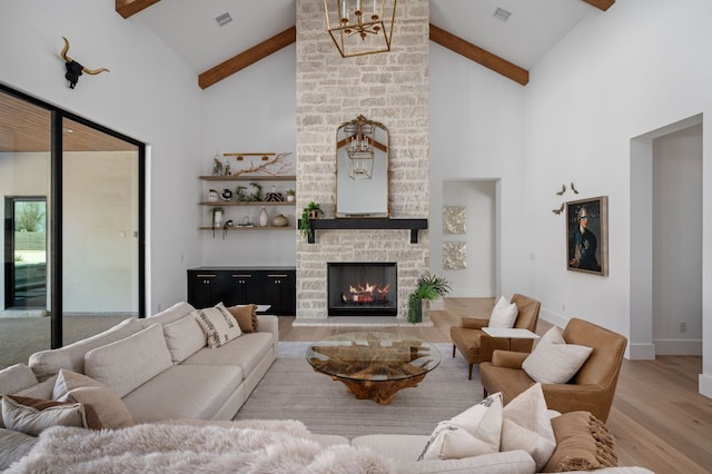 200 Birdstone Ln, Georgetown, TX 78628 - living area featuring a fireplace, wood finished floors, beam ceiling, high vaulted ceiling, and a chandelier
