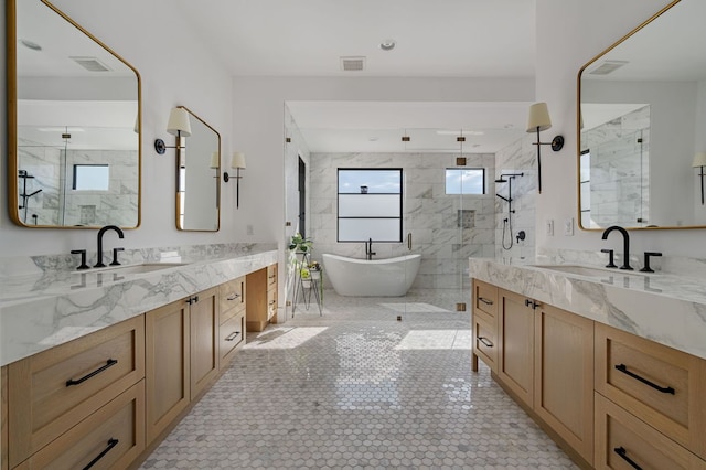 full bathroom with a shower stall, two vanities, and a sink