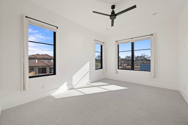 unfurnished room with carpet floors, baseboards, and a ceiling fan