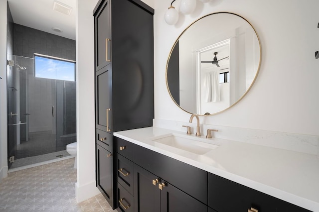 bathroom featuring toilet, a shower stall, and vanity