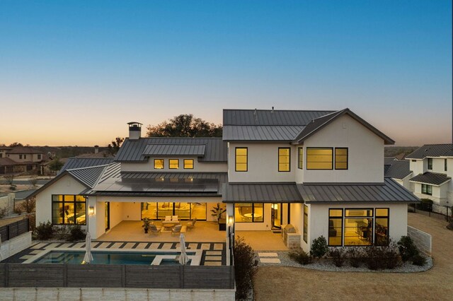 200 Birdstone Ln, Georgetown, TX 78628 - rear view of house with a standing seam roof, stucco siding, a fenced backyard, and a metal roof