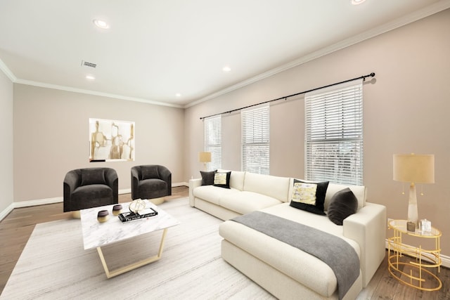 living room featuring visible vents, baseboards, wood finished floors, and crown molding