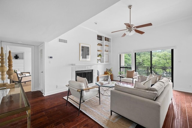 living room with visible vents, a fireplace, baseboards, and hardwood / wood-style flooring