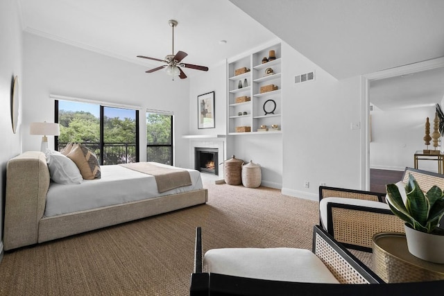 bedroom with carpet flooring, a warm lit fireplace, visible vents, and baseboards