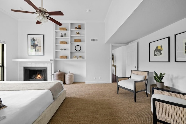 bedroom featuring carpet, visible vents, ornamental molding, a tile fireplace, and baseboards