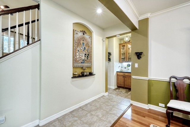 corridor featuring ornamental molding, light wood-type flooring, baseboards, and recessed lighting