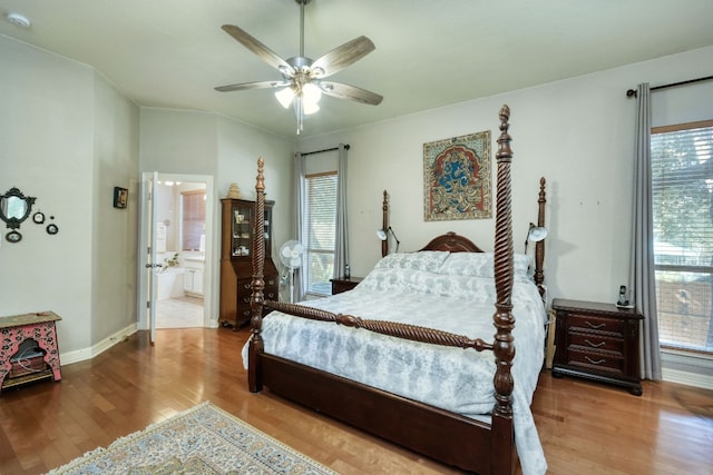 bedroom featuring a ceiling fan, baseboards, wood finished floors, and ensuite bathroom