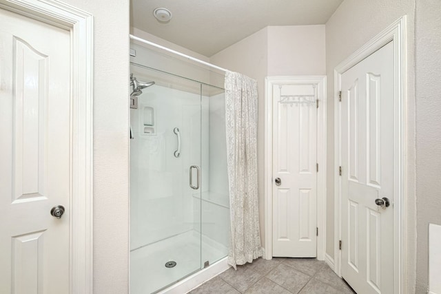 full bathroom with a shower stall and tile patterned flooring