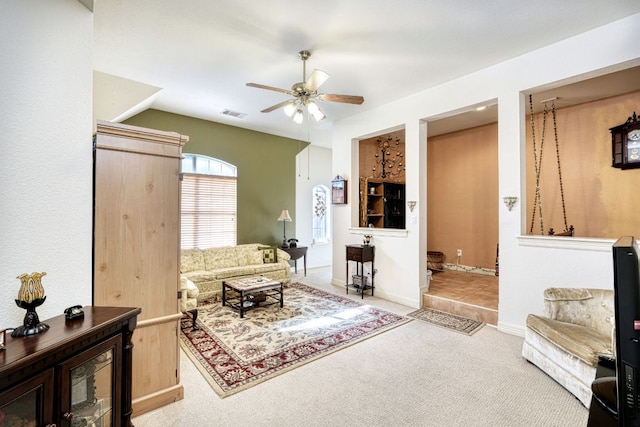 living area featuring baseboards, carpet floors, visible vents, and a ceiling fan