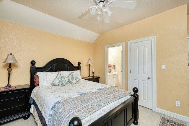 bedroom with light colored carpet, a ceiling fan, vaulted ceiling, ensuite bath, and baseboards