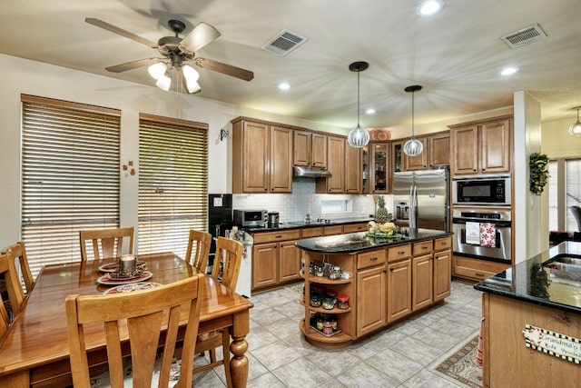 kitchen featuring black appliances, tasteful backsplash, under cabinet range hood, and visible vents